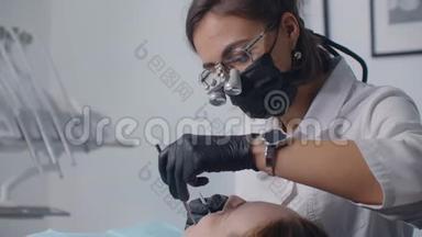 女牙医和病人一起工作。 媒体。 女牙医用专业牙齿检查及治疗病人牙齿